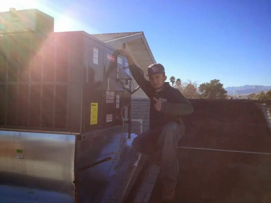 HVAC technician performing Heat Pump Repair on a rooftop unit in Hudson